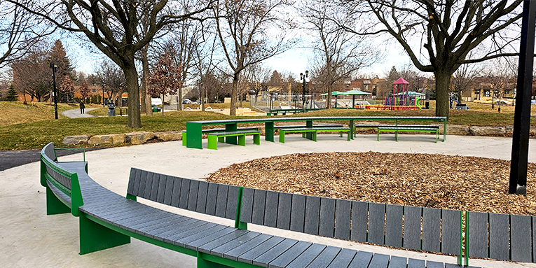 Banc en arc de cercle avec dossiers dans un contexte de parc urbain. Mobilier urbain.