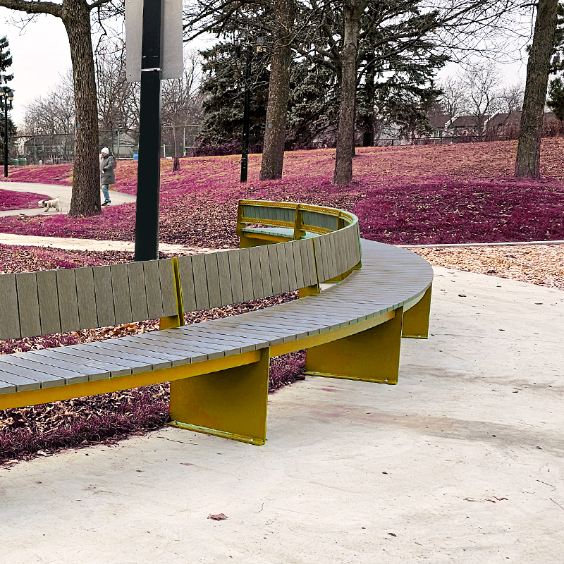 Banc en arc de cercle dans un contexte de parc urbain. Mobilier urbain.